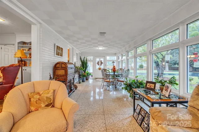 a living room filled with furniture a rug and a large window