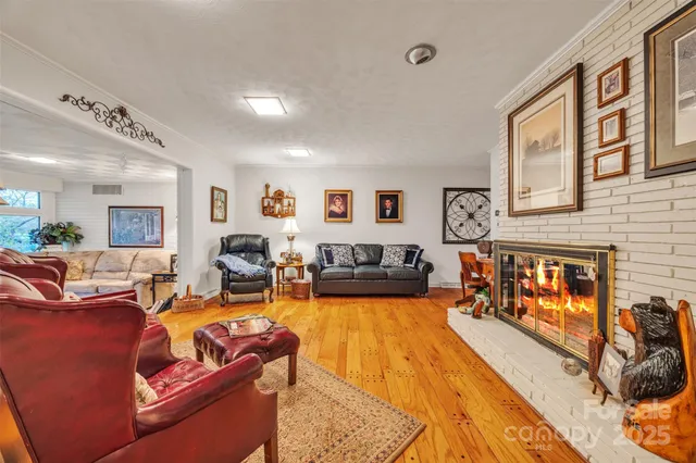 a living room with furniture large window and wooden floor