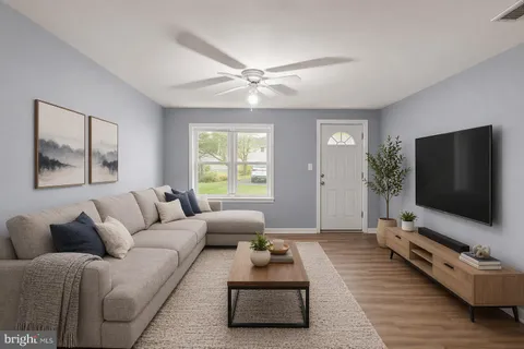a living room with furniture and a ceiling fan