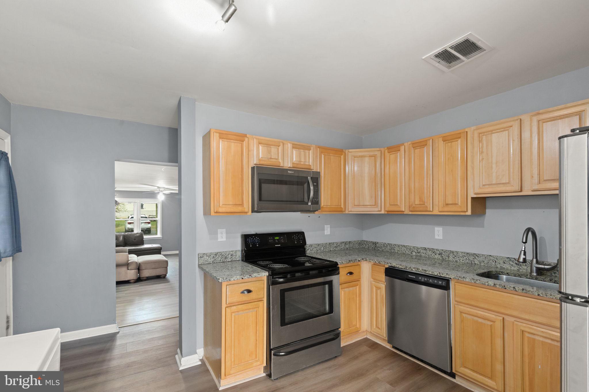 4121 Conowingo Road Darlington, MD 21034 - Photo 7 of 24 a kitchen with granite countertop a stove top oven a sink dishwasher and a refrigerator with wooden floor