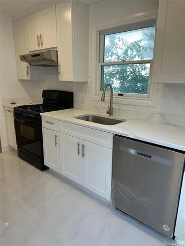 a kitchen with stainless steel appliances white cabinets and a sink