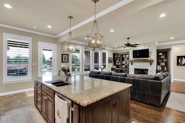 a kitchen with stainless steel appliances granite countertop a sink a stove and a wooden floors