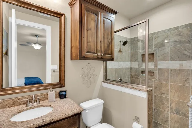 a bathroom with a granite countertop sink toilet and shower
