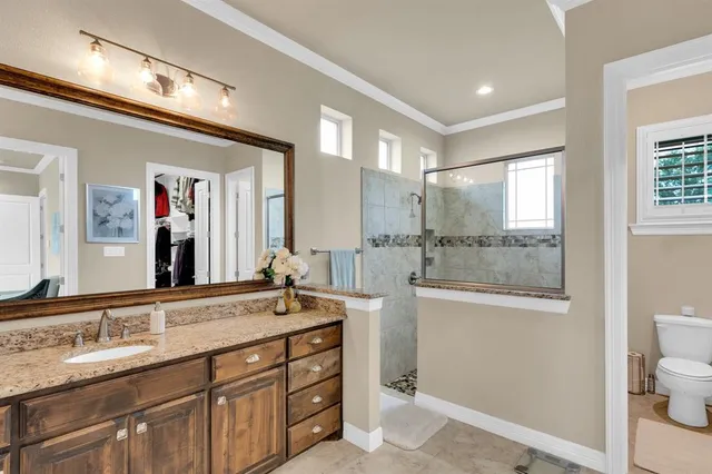 a bathroom with a granite countertop sink mirror and a toilet
