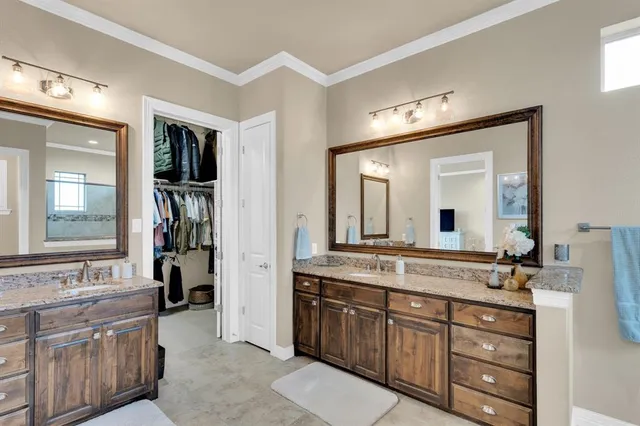 a bathroom with a granite countertop double vanity sink and a mirror