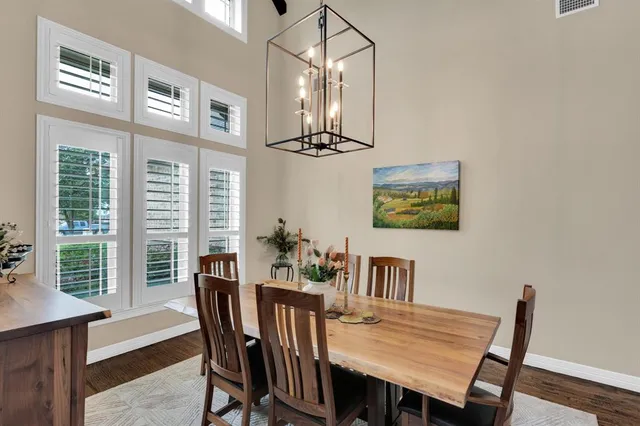 a view of a dining room with furniture a chandelier and wooden floor
