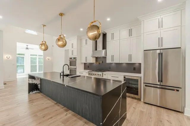 a kitchen with stainless steel appliances a stove a sink and a refrigerator