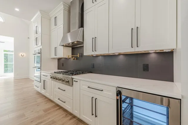 a kitchen with a refrigerator a sink and dishwasher with wooden floor