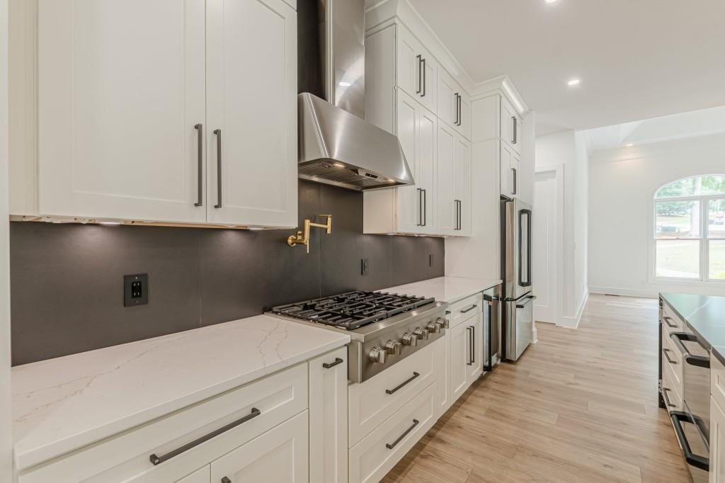 6394 Wood Valley Road Douglasville, GA 30134 - Photo 15 of 84 a kitchen with stainless steel appliances a refrigerator a stove and white cabinets with wooden floor