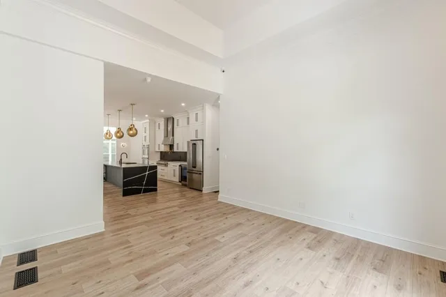 a view of a hallway with wooden floor and a living room