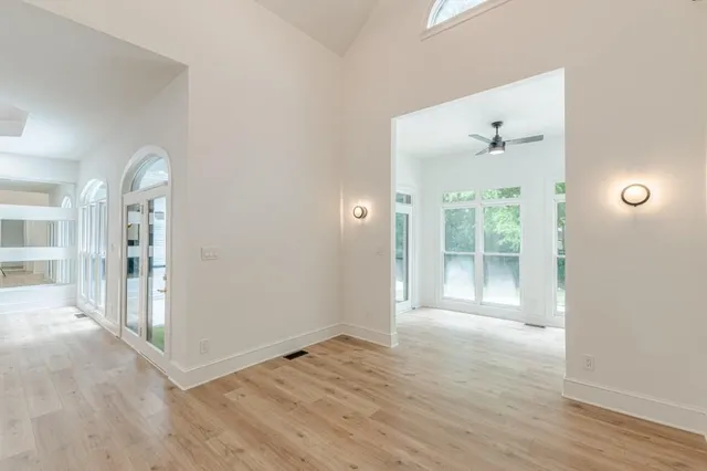 an empty room with wooden floor and window