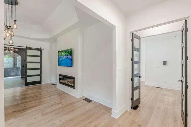 a bedroom with a bed a flat screen tv and couches