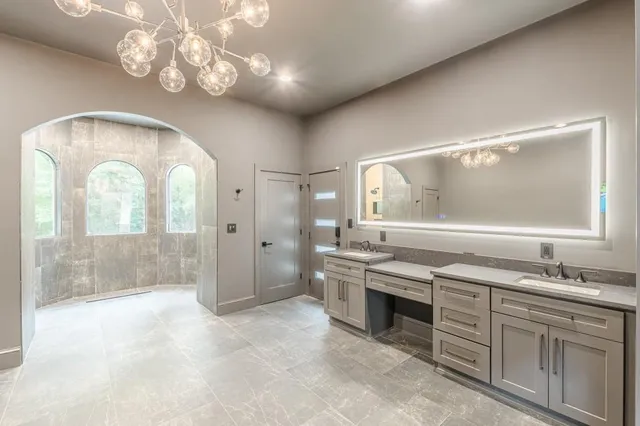 a bathroom with a sink a toilet a mirror and shower