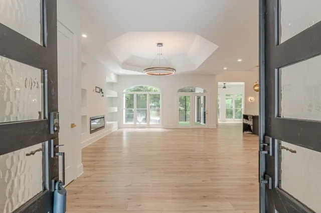a view of large kitchen with granite countertop a stove a sink a refrigerator and white cabinets with wooden floor