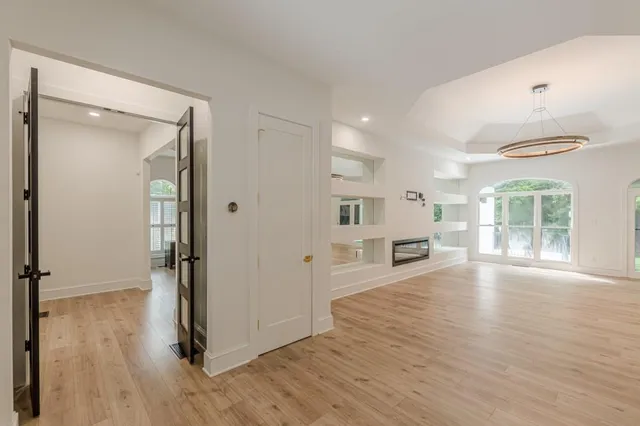 a view of an empty room with window and cabinet