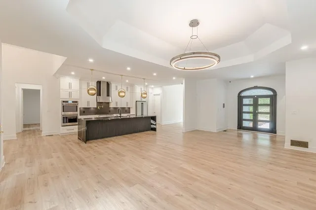 a large kitchen with stainless steel appliances a large counter top and a wooden floors