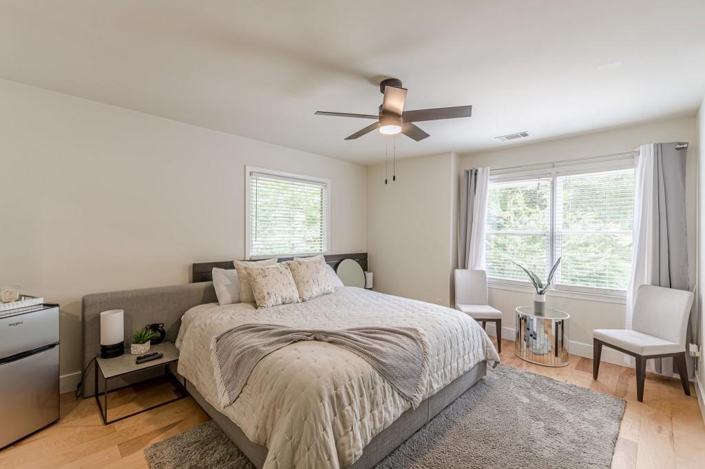 6394 Wood Valley Road Douglasville, GA 30134 - Photo 83 of 84 a bedroom with a large bed and a chandelier