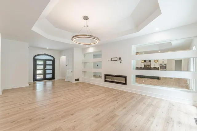 a kitchen with stainless steel appliances a refrigerator a stove and white cabinets with wooden floor