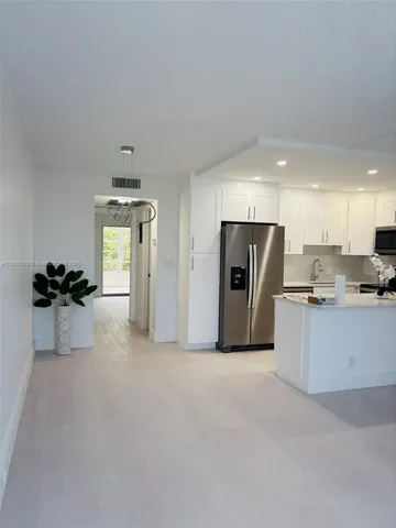 a view of kitchen with refrigerator microwave and stove