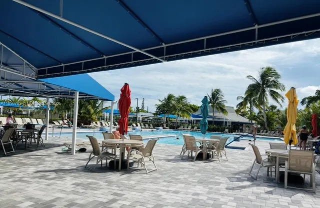 a front view of a house with swimming pool and garden