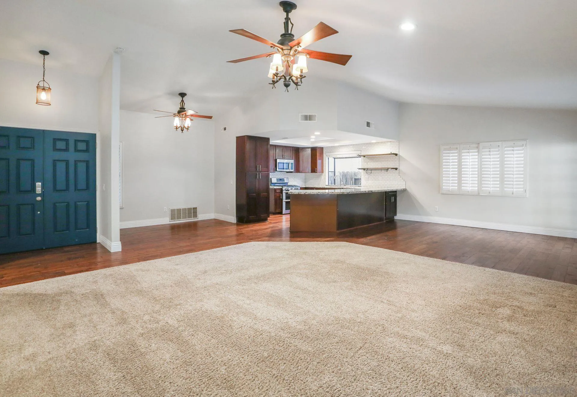 9260 Sombria Road Lakeside, CA 92040 - Photo 5 of 31 a view of a kitchen with a stove cabinets a ceiling fan and wooden floor