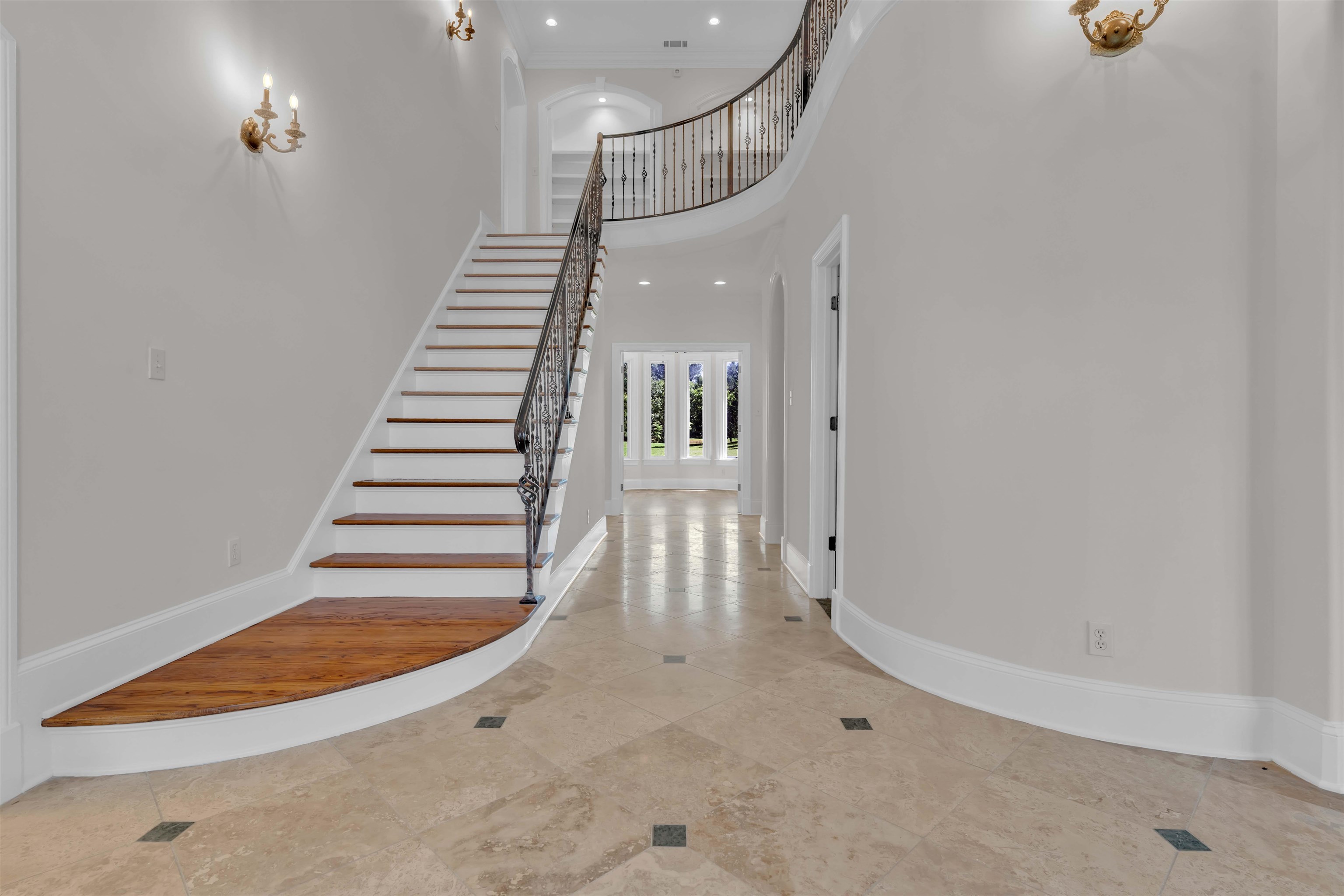 680 Highway 193 Collierville, TN 38017 - Photo 6 of 38 Grand foyer showcasing a curved staircase with wrought iron balusters and wood-finish treads