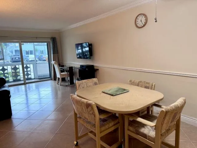 a view of a dining room and livingroom with furniture wooden floor and a clock