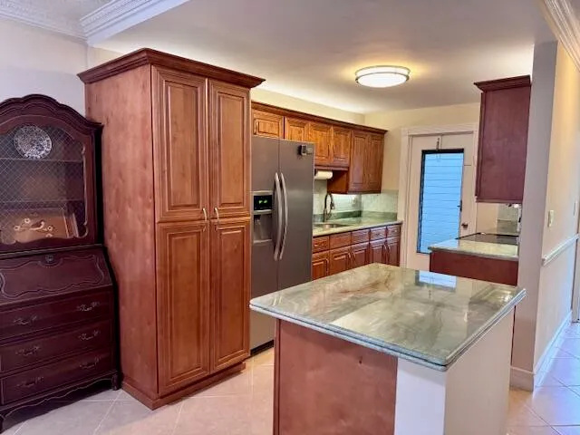 a kitchen with granite countertop a refrigerator and wooden cabinets