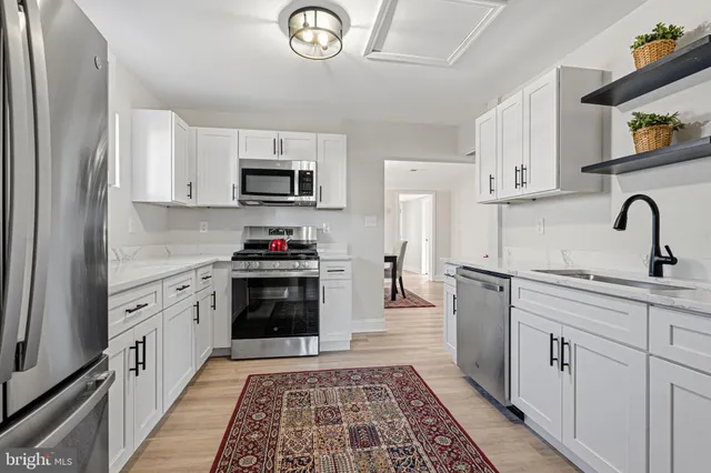 a kitchen with stainless steel appliances granite countertop a refrigerator and a stove top oven
