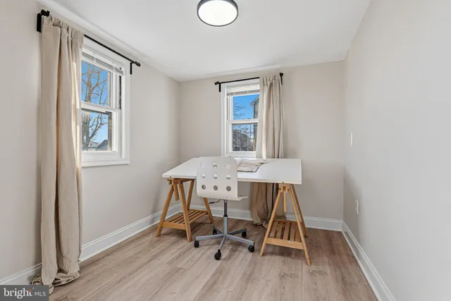 a view of a workspace with furniture and wooden floor
