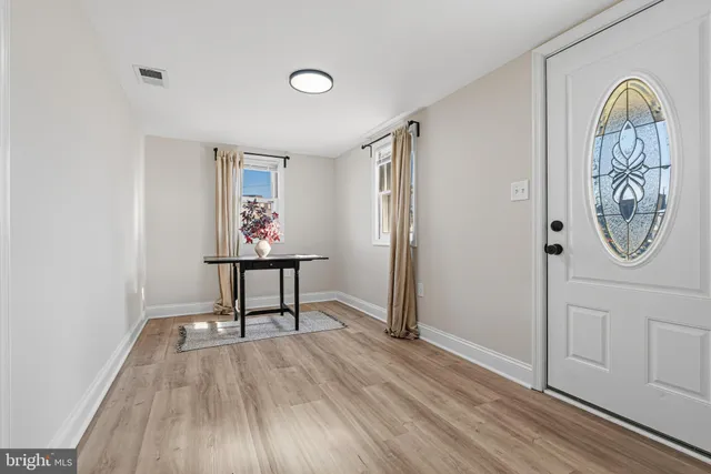 a view of a hallway with wooden floor and entryway