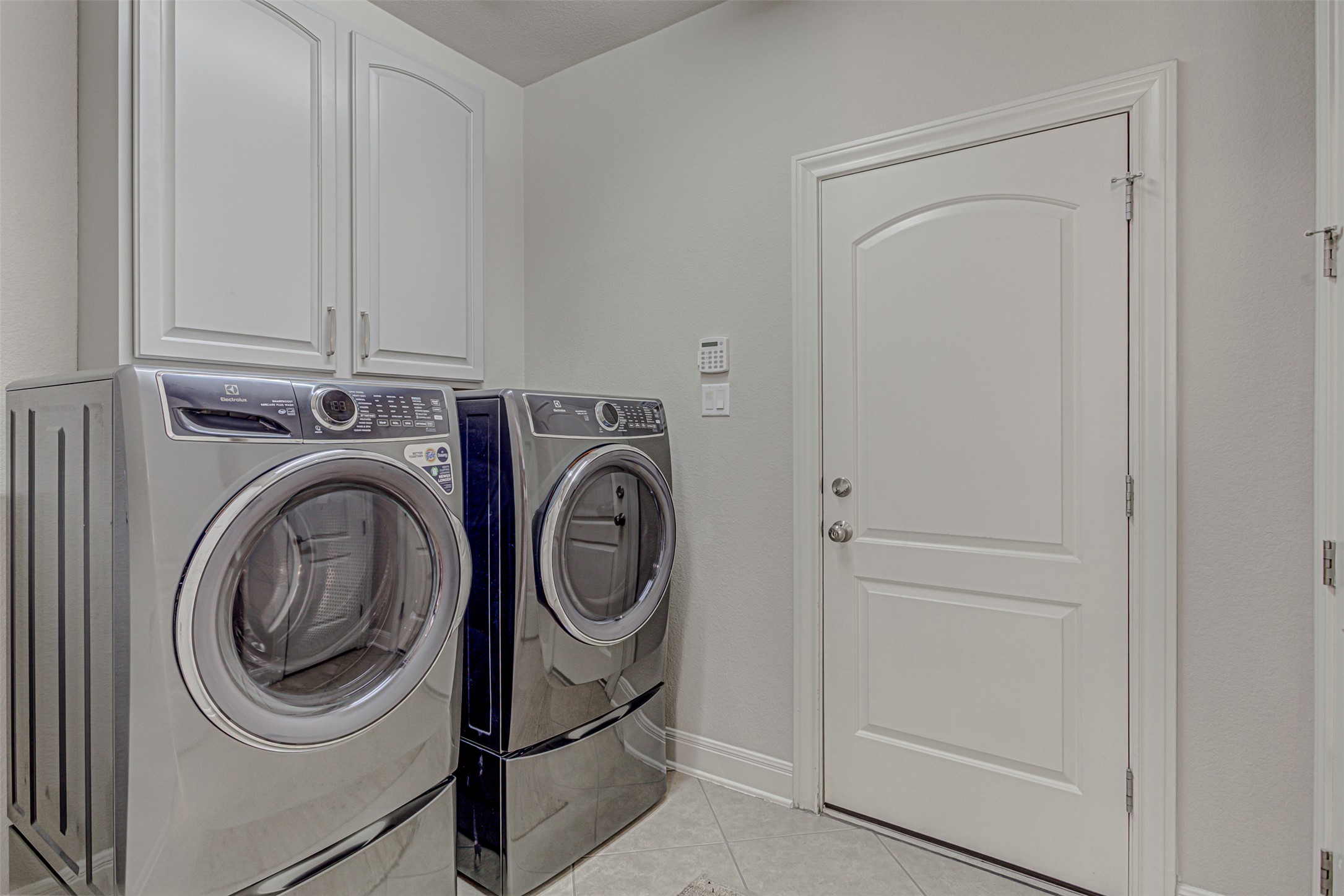 110 Sebastians Run Austin, TX 78738 - Photo 18 of 40 Laundry area with light tile patterned flooring, separate washer and dryer, and cabinet space