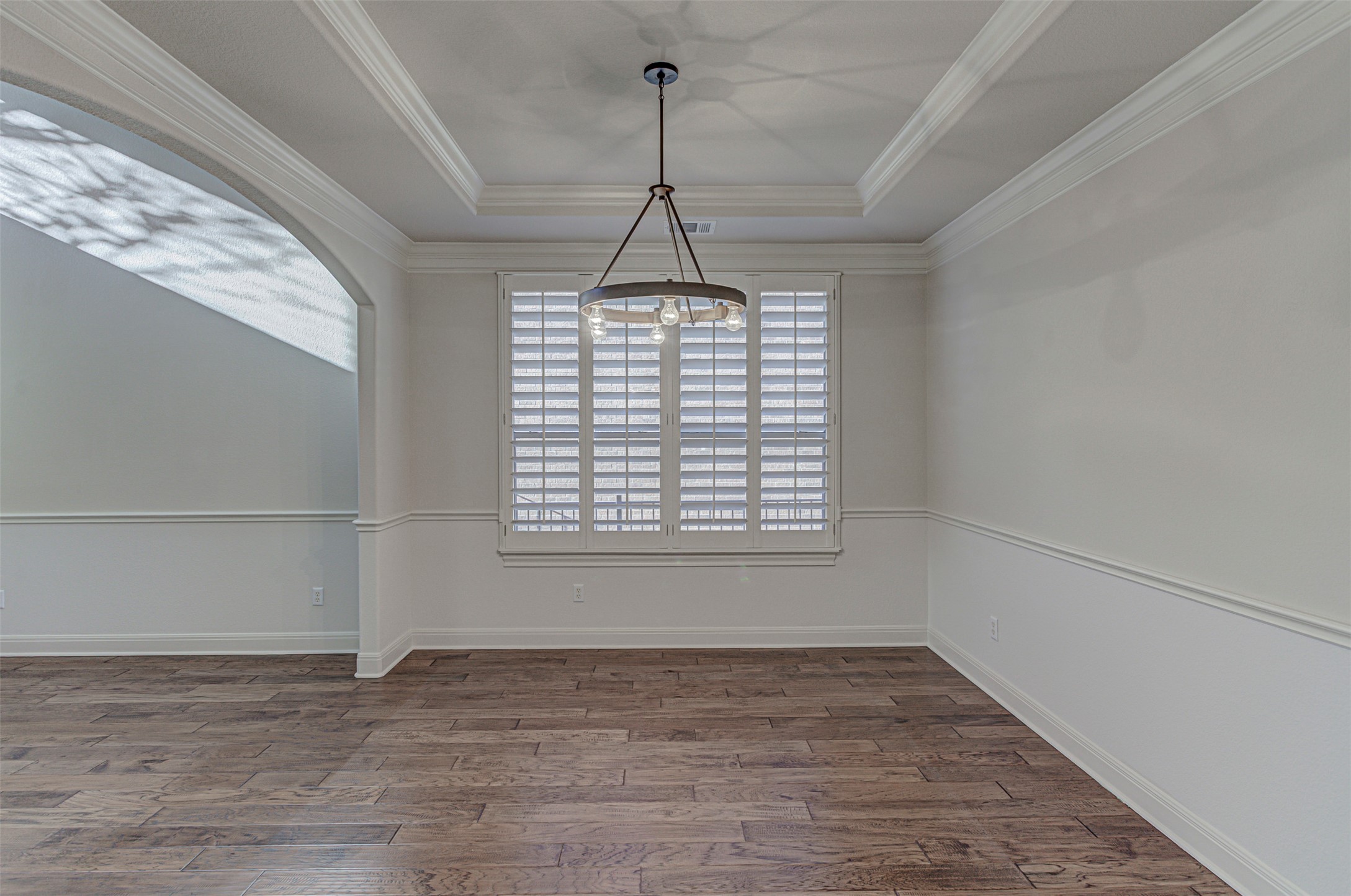 110 Sebastians Run Austin, TX 78738 - Photo 9 of 40 Spacious dining area featuring, a tray ceiling, and a modern chandelier