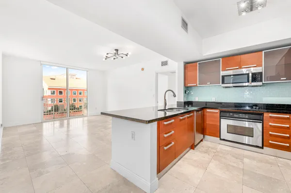 a large kitchen with stainless steel appliances granite countertop a stove and a sink