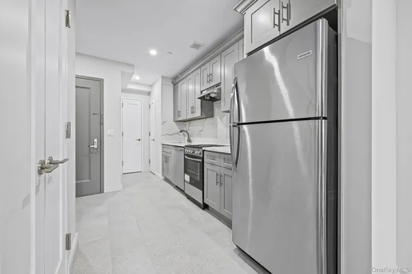 a white refrigerator freezer and a stove sitting inside of a kitchen