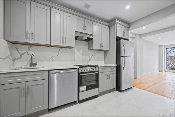 a kitchen with white cabinets and stainless steel appliances