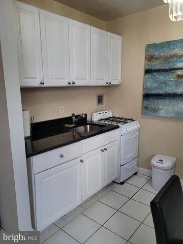 a bedroom with a bed a couch and dresser next to a window