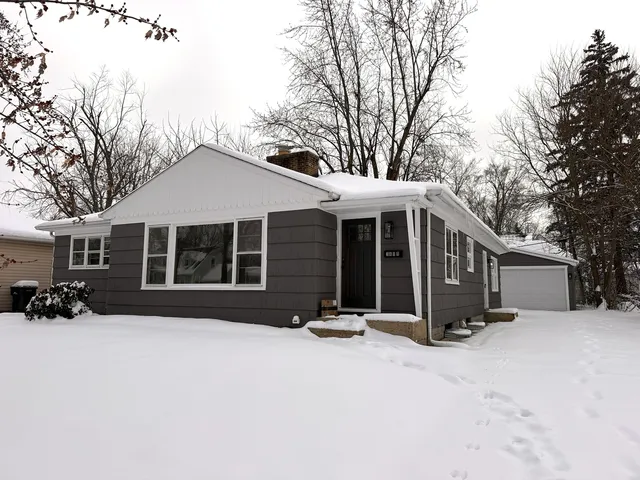 a front view of a house with a yard covered in snow