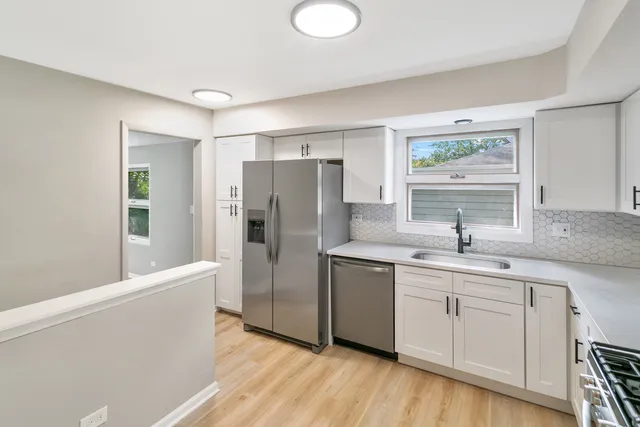 a kitchen with a refrigerator sink and cabinets