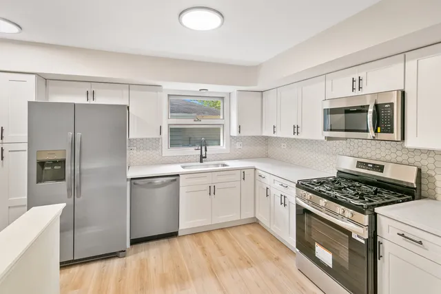 a kitchen with stainless steel appliances granite countertop a stove a sink and a refrigerator