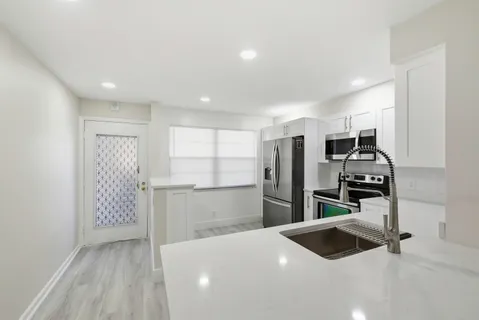 a kitchen with a refrigerator and a sink