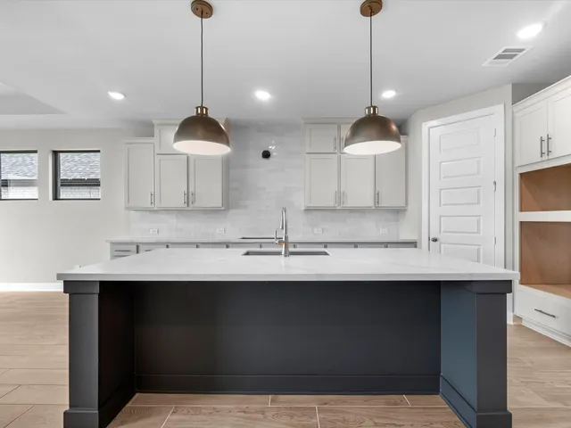 a kitchen with a sink a counter space cabinets and appliances