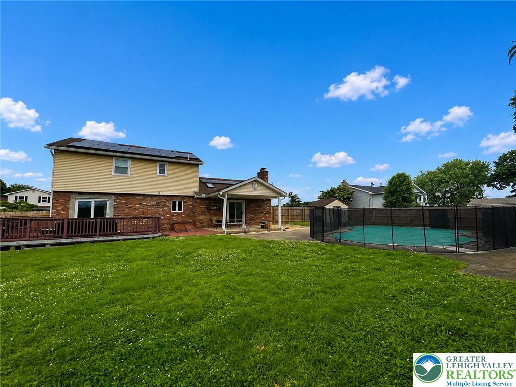 A spacious backyard features a deck, lush lawn, and a fenced swimming pool which was not open due to moving plans