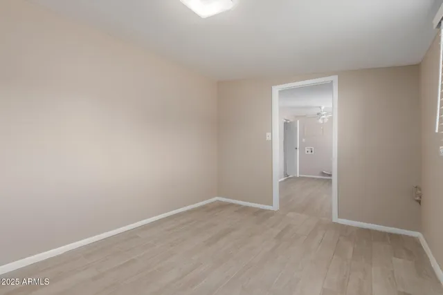 a view of an empty room with wooden floor and closet