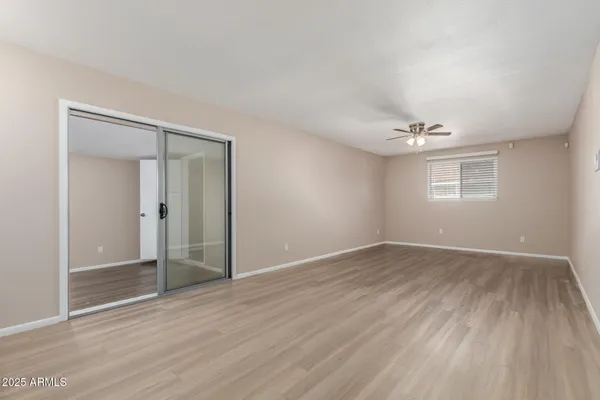an empty room with wooden floor and windows