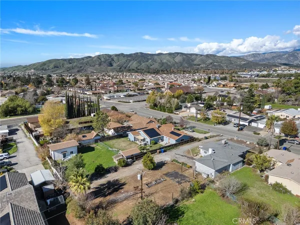 an aerial view of a city with lots of residential buildings and mountain view in back