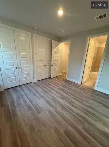 a view of an empty room with wooden floor