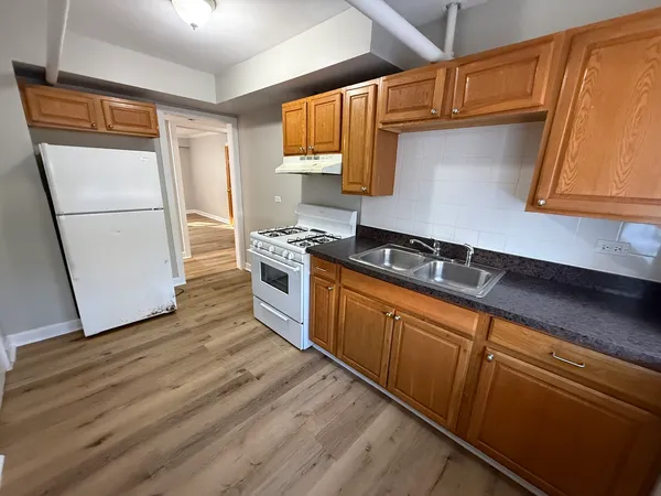 a kitchen with granite countertop wooden floors and stainless steel appliances