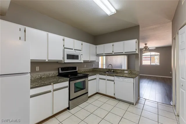 a kitchen with granite countertop cabinets stainless steel appliances and a sink