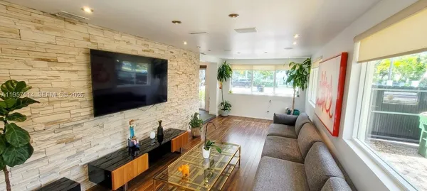 a view of a hallway with furniture and a potted plant